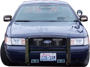 2001 Ford Crown Victoria - This 2001 Ford Crown Victoria police car is shown from the front, equipped with a push bar and emergency lights.