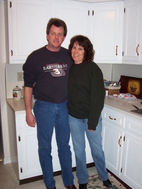 1994 Ford Bronco - Couple poses for a photo in a kitchen with white cabinets and countertops.