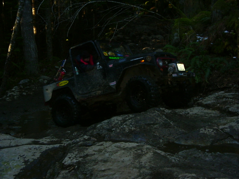Black off-road vehicle on rocks, Supermotors.net logo visible