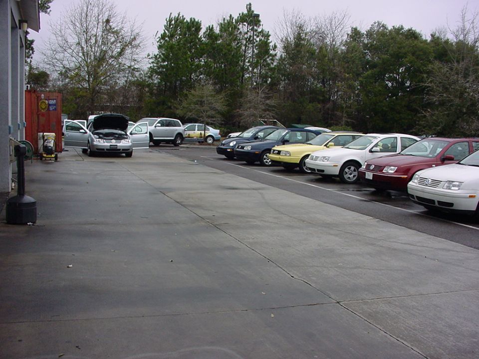 Row of Volkswagen Jettas parked in a lot, one with hood open