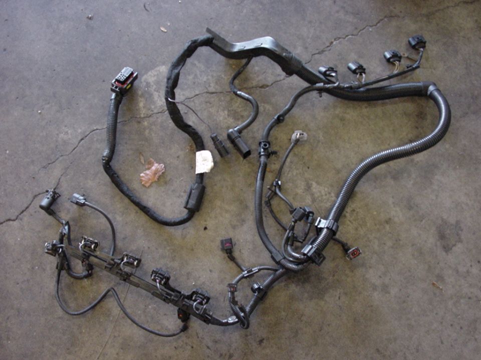 Engine wiring harness with multiple connectors and black protective tubing