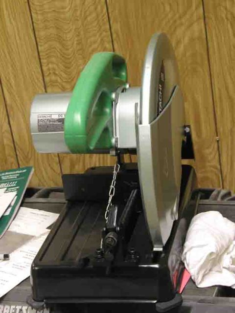 1988 Ford Bronco - A metal chop saw with a green handle and silver blade guard is shown on a black base.