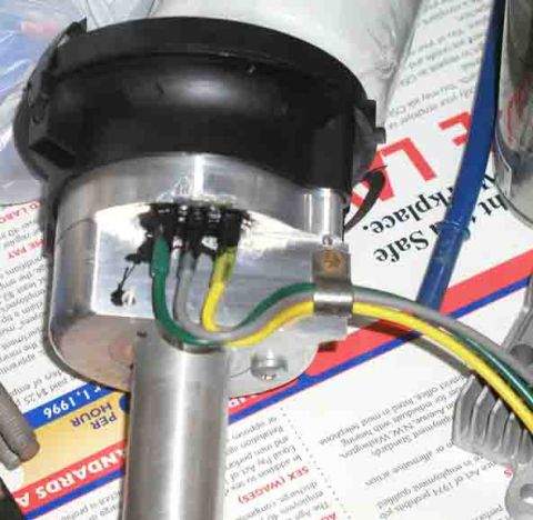 1988 Ford Bronco - A close-up view of a vehicle's distributor cap and wiring, with various documents visible in the background.