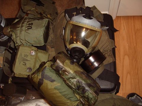 1988 Ford Bronco - A gas mask, filter, canteen, and medical pouch are laid out on the floor, suggesting military deployment gear.