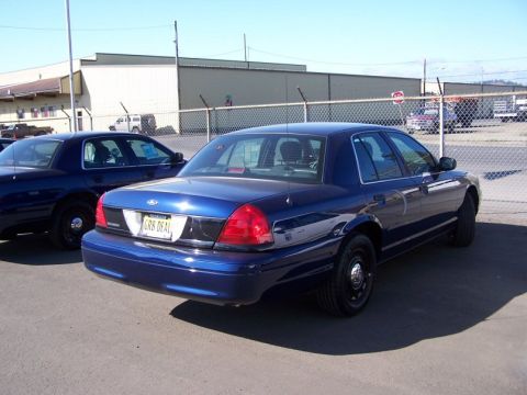 2001 Ford Crown Victoria - Rear view of a blue 2001 Ford Crown Victoria, parked next to another similar vehicle.