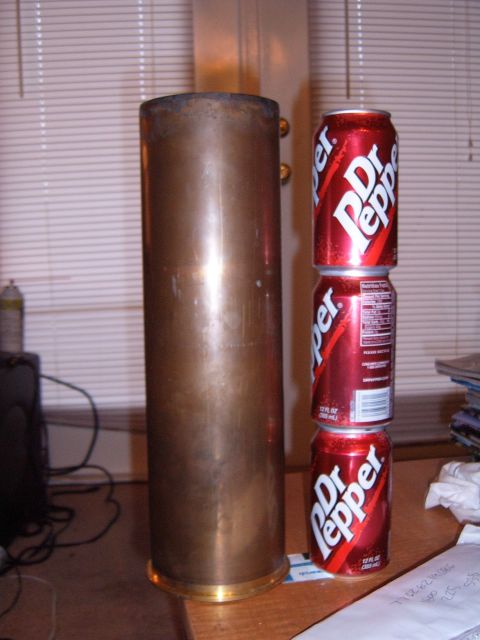 1988 Ford Bronco - A large brass cylinder and three Dr. Pepper cans are arranged on a table.