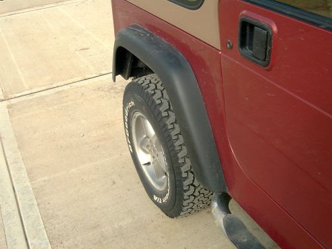 1998 Jeep TJ - Close-up of a Jeep Wrangler's rear wheel and side panel, with a watermark at the bottom.