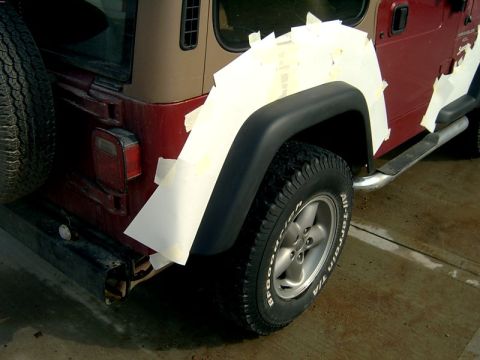 1998 Jeep TJ - This 1998 Jeep TJ has white tape applied to its rear fender, possibly for bodywork or modification.
