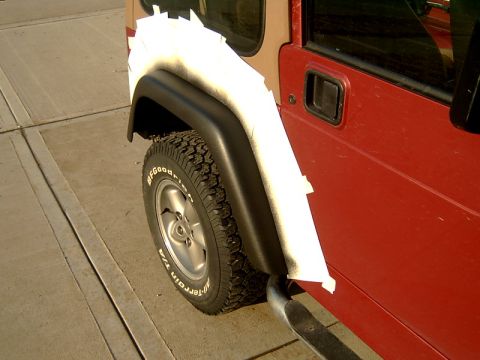 1998 Jeep TJ - Jeep TJ fender flare taped off for paint application. The body style is consistent with a 1997 model year.