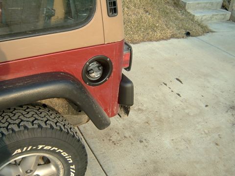 1998 Jeep TJ - Close-up of the rear driver's side of a 1998 Jeep TJ, showing the fuel filler cap and tire.