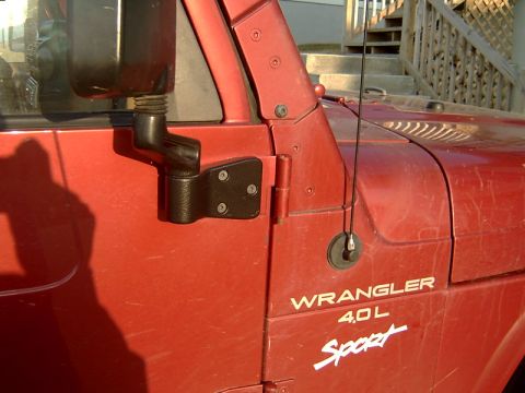 1998 Jeep TJ - The side of a red Jeep Wrangler is shown, a decal and a side mirror.
