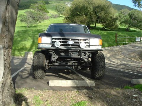 1989 Ford Bronco - This lifted Ford truck features a prominent grille and large off-road tires, suggesting a model year earlier than 1989.
