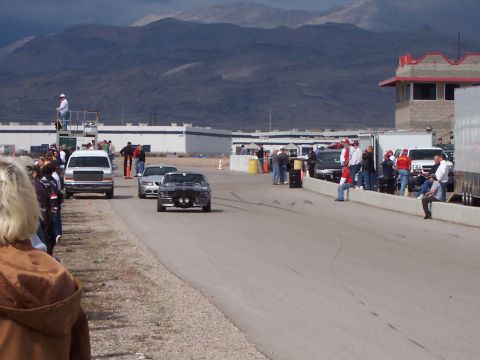 1971 Ford Mustang - A classic Mustang races down the track with spectators watching from the side.