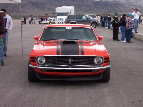 1971 Ford Mustang - Front view of a red 1970 Ford Mustang parked outdoors with a black stripe detail.