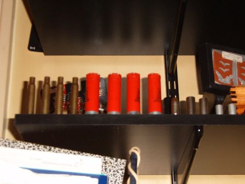1993 Ford Bronco - A collection of ammunition, including red shotgun shells and brass casings, is displayed on shelves.