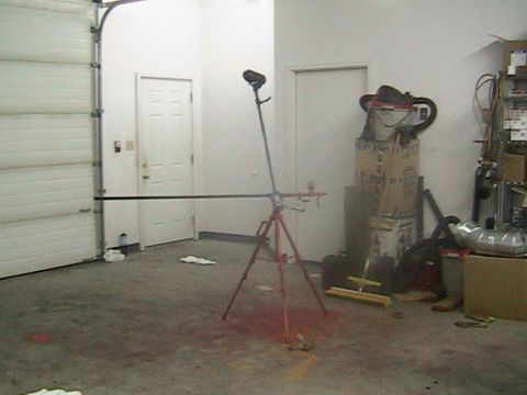 1981 Chevrolet C/K Pickup - Interior of a garage with a large overhead door, a tripod with a light, and various stored items.