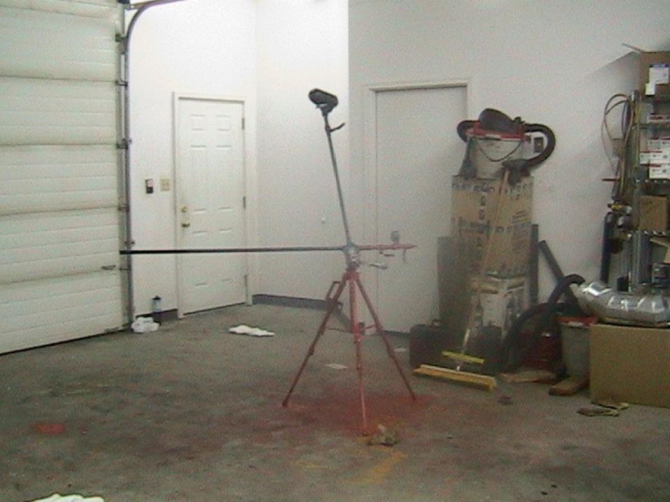 Garage with open door, tripod with light, boxes, and tools