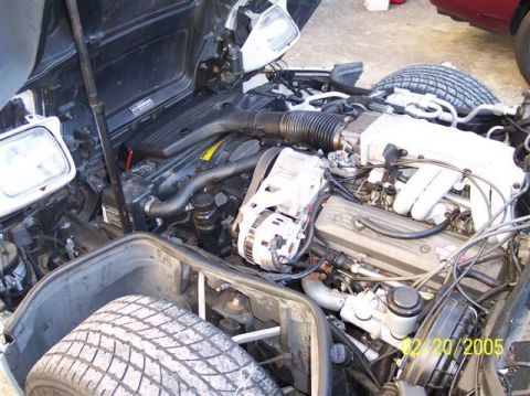 1994 Ford Bronco - View of a vehicle's engine bay, with tires partially visible in the foreground and background. A timestamp indicates the photo was taken on…