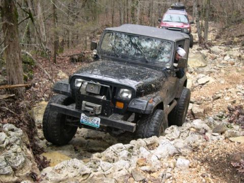 1999 Jeep TJ - Jeep Wrangler navigating a difficult rocky off-road course with another vehicle following.