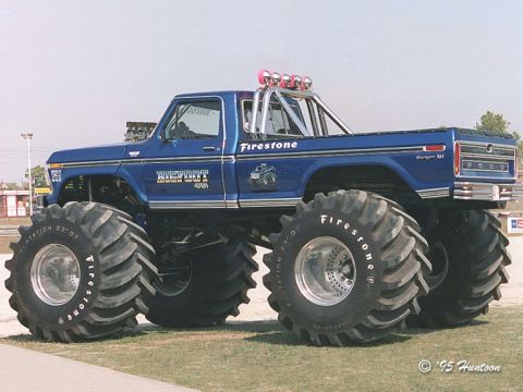 1986 Ford Bronco - This blue Bigfoot monster truck features oversized Firestone tires and a prominent roll bar, indicating its off-road capabilities.