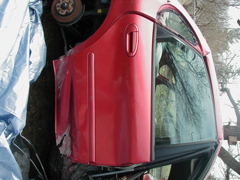 1997 Ford Taurus - A red 1997 Ford Taurus is seen from the side, with its door and fender prominently displayed.