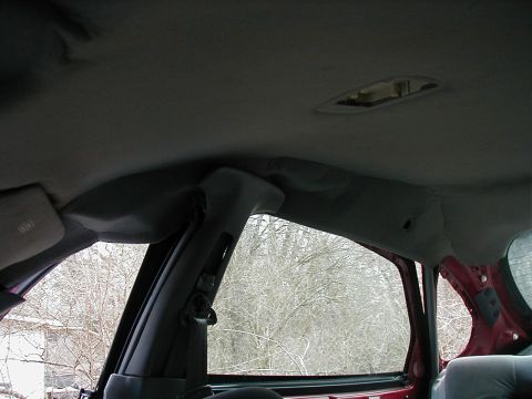 1997 Ford Taurus - Interior view showing the headliner, A-pillar, and window frame of a vehicle.