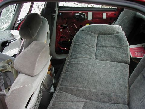 1997 Ford Taurus - Interior of a car showing damaged door panel and torn upholstery.