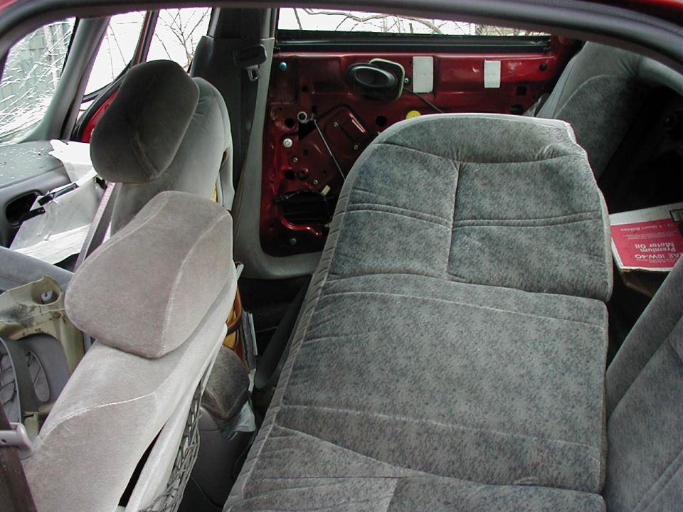 Interior view of a car with damaged door panel and torn upholstery