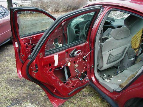 1997 Ford Taurus - The interior of a 1997 Ford Taurus is visible with both doors removed, revealing the exposed wiring and seats.