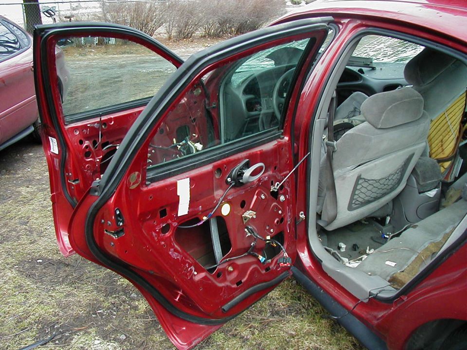 1997 Ford Taurus interior with doors removed, showing exposed wiring and seats