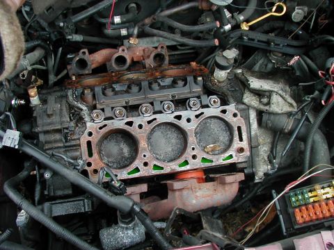 1997 Ford Taurus - The engine's cylinder head has been removed, exposing the pistons and the top of the cylinders.