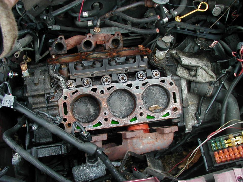 engine block with cylinder head off, showing pistons and valves