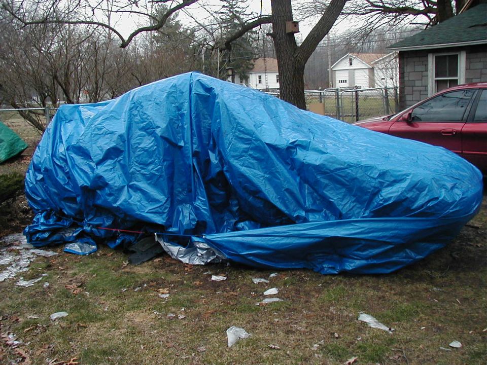 Car covered in a blue tarp