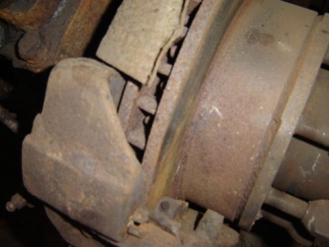 1992 Ford Bronco - Close-up of a heavily rusted brake caliper and rotor assembly.