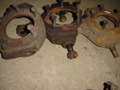1992 Ford Bronco - These old, rusty steering knuckles are laid out on a concrete surface.