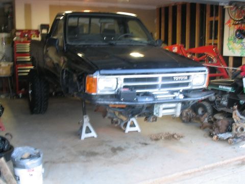 1986 Ford F-150 - This Toyota pickup truck is undergoing front-end repairs in a garage setting.