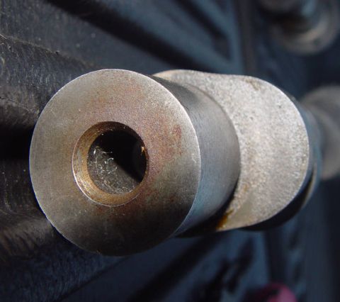 1969 Ford Fairlane - A close-up view of a metal camshaft lobe, showing its cylindrical shape and a central hole.