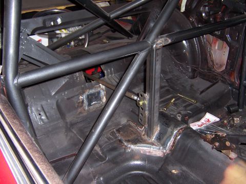 1971 Ford Mustang - The interior of the car shows extensive modifications with a roll cage and welded metal plates on the floor.