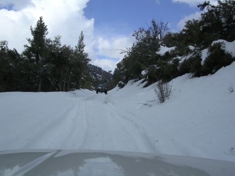 1999 Toyota Tacoma - An SUV navigates a snowy mountain road, with another vehicle visible ahead.