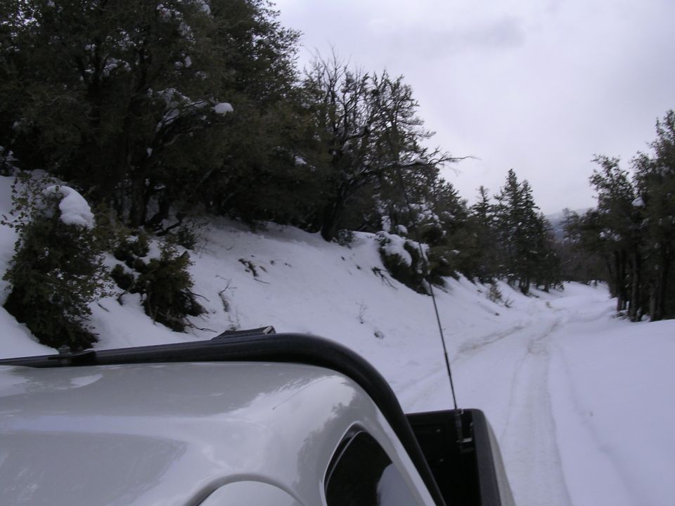 White truck driving on a snowy mountain road