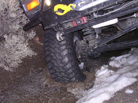 1999 Toyota Tacoma - This vehicle is stuck in a muddy and snowy area, with its tire deep in the muck.