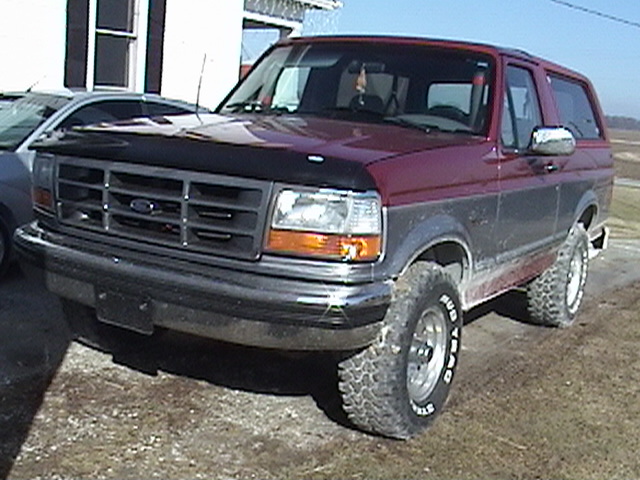 Maroon and gray Ford Bronco parked next to a silver car