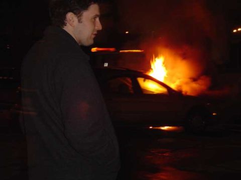 1979 Ford Bronco - A car is seen burning intensely at night, with smoke and flames obscuring much of the vehicle.