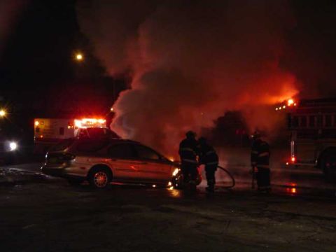 1979 Ford Bronco - Firefighters battle a car fire at night, with an ambulance and fire truck visible in the background.
