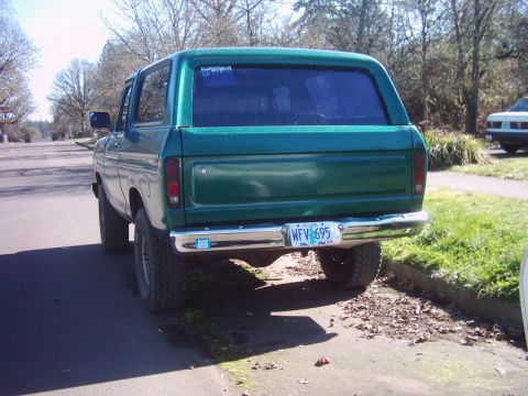 1978 Ford Bronco - Rear view of a green 1978 Ford Bronco parked on the side of a residential street.
