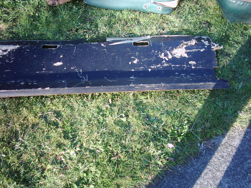 Black tailgate with peeling paint and visible damage