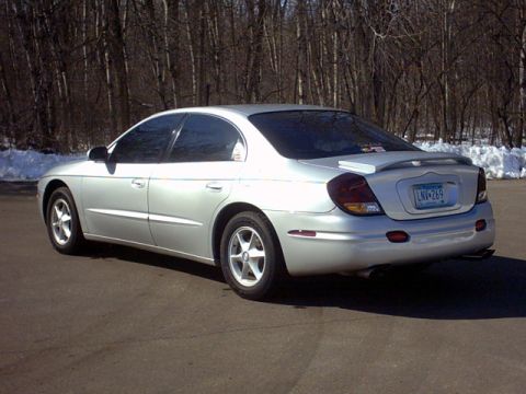 2002 Oldsmobile Aurora - Rear view of a 2002 Oldsmobile Aurora sedan parked outdoors with a spoiler and tinted windows.