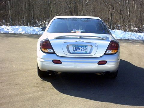 2002 Oldsmobile Aurora - This silver sedan is parked outdoors with snow on the ground and trees in the background.