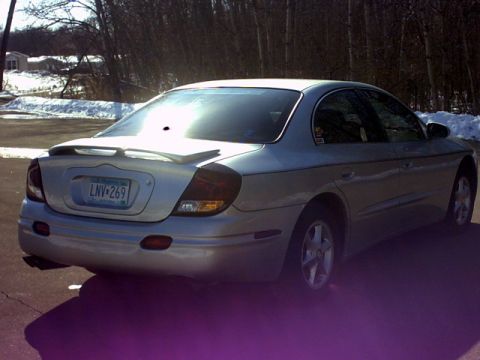 2002 Oldsmobile Aurora - The rear view of a silver sedan shows a spoiler and a license plate.