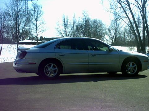 2002 Oldsmobile Aurora - Side profile of a silver 2002 Oldsmobile Aurora sedan parked on asphalt.